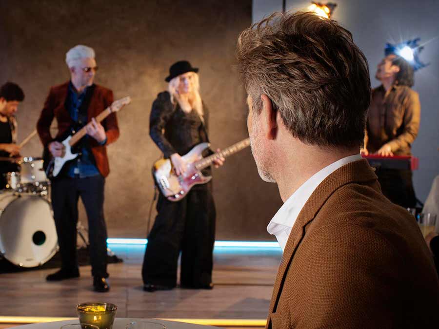 A patient in Belfast wears Oticon More Hearing aids for music lovers as he watches a gig