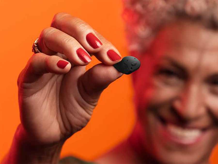 Signia Insio Charge Go AX Hearing Aids available at True Tone Hearing Northern Ireland - here a clinic patient is holding up a hearing aid to show how small it is